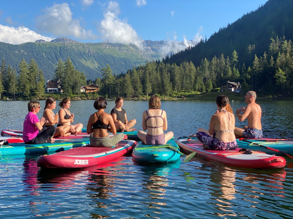 Cours de yoga sur paddle sur le lac de Champex.