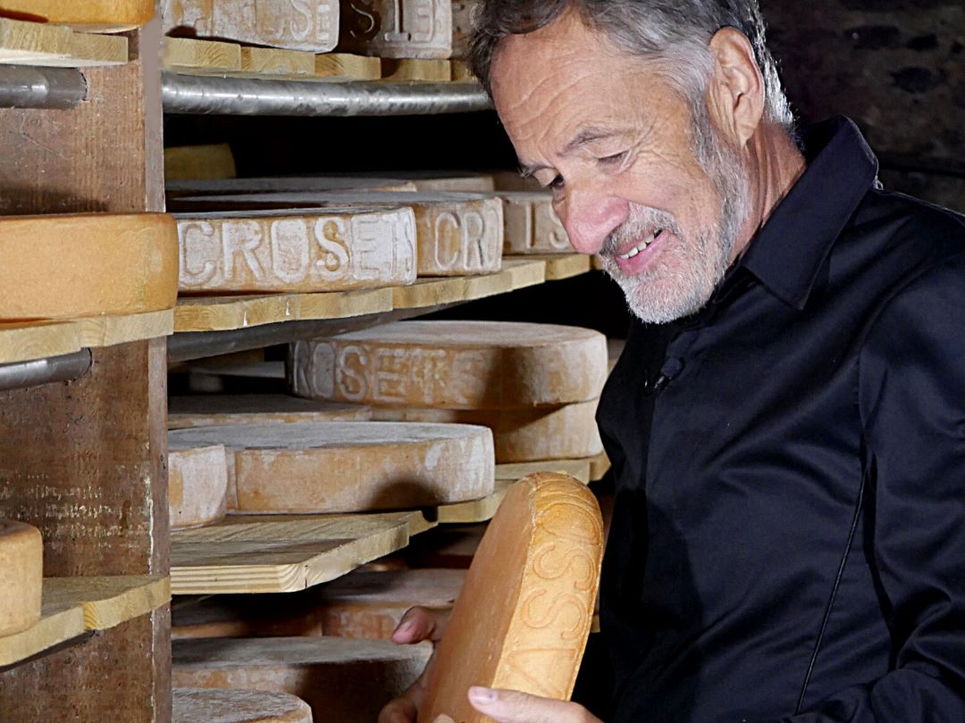 Claude Luisier dans sa cave de Leytron (VS) une meule de fromage à raclette en main.